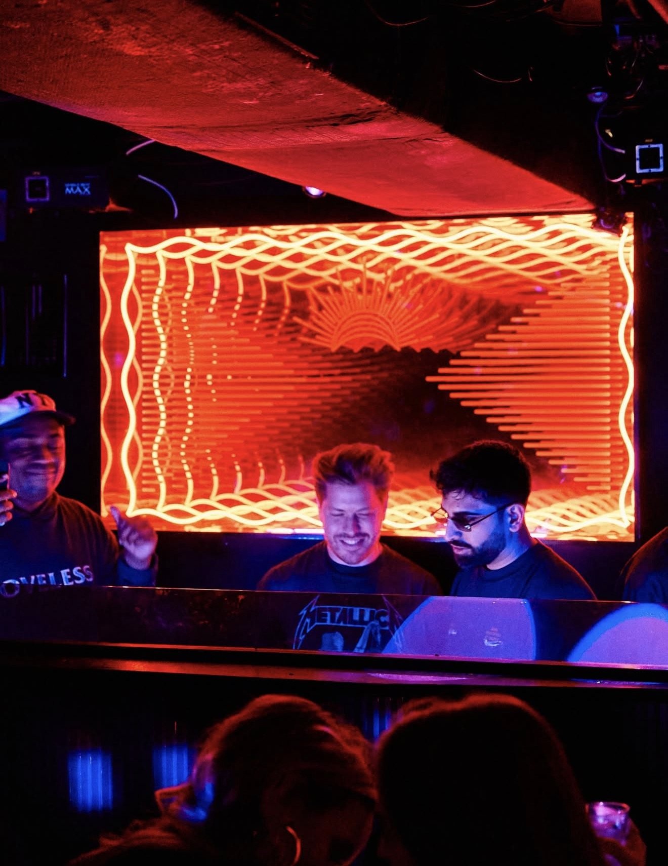 DJs at the Virgo booth in front of a glowing orange infinity-mirror wall