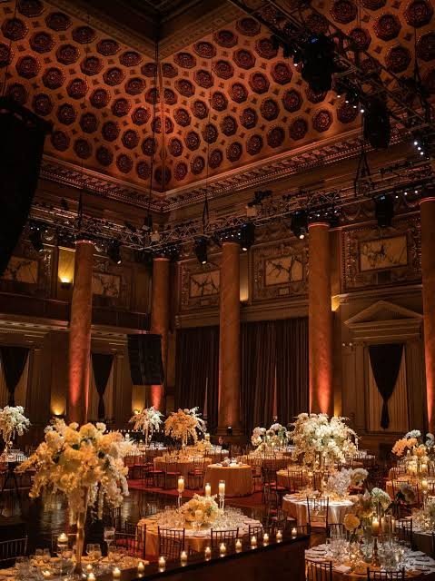 Candlelit gala tables with white florals beneath the coffered ceiling