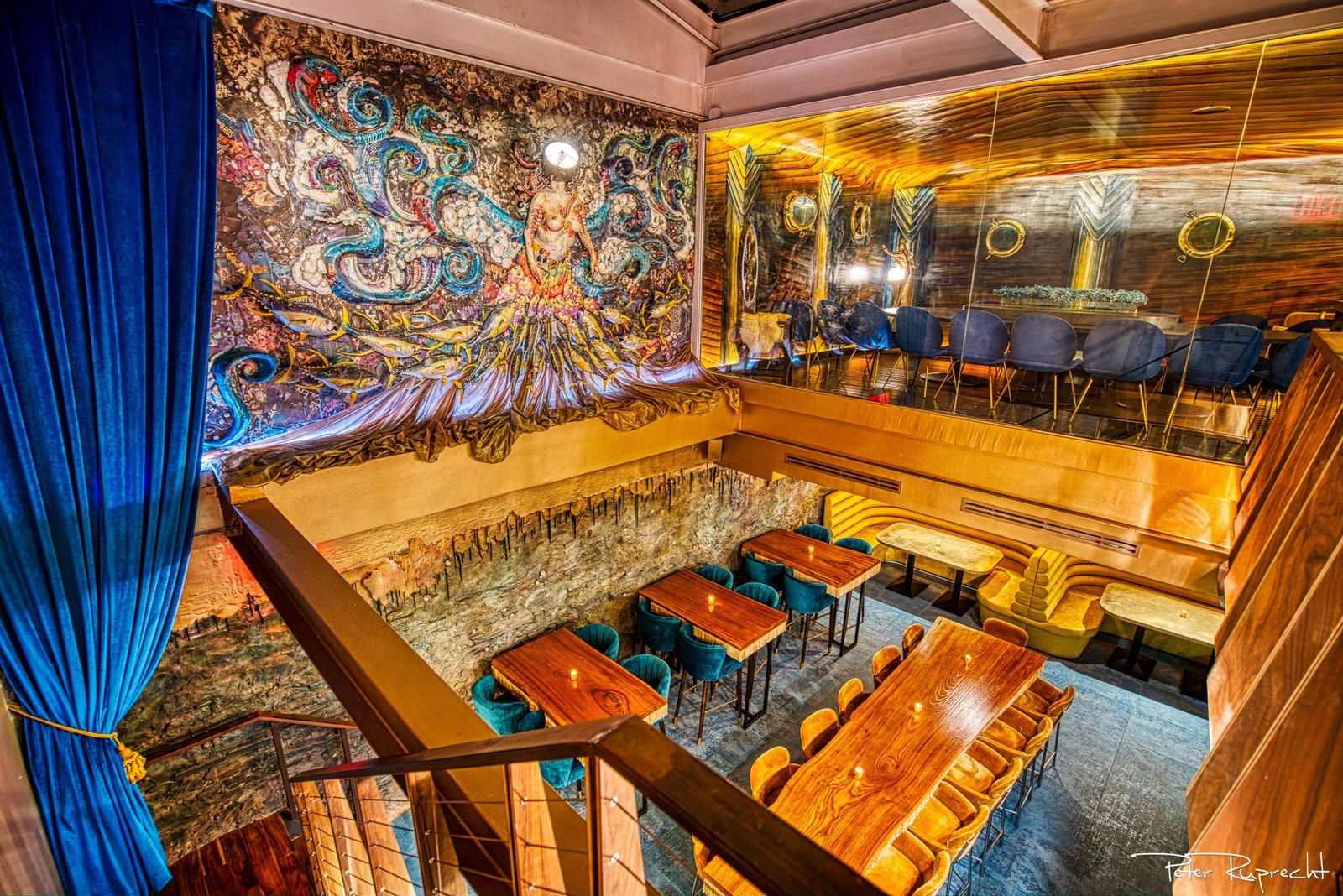 The gold-lit lower room with a swirling sea mural