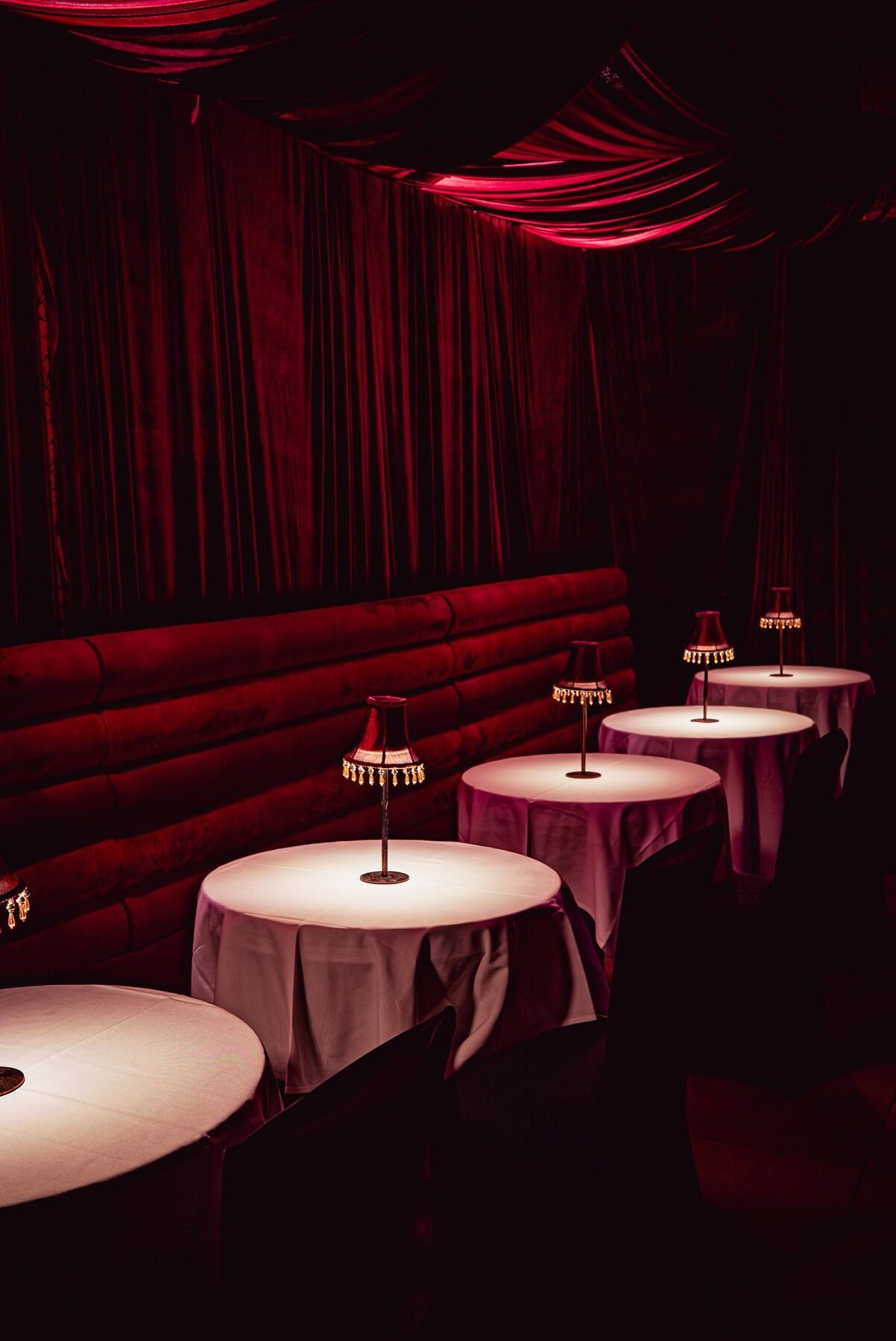 The private Desire Room with a velvet banquette and lamp-lit tables